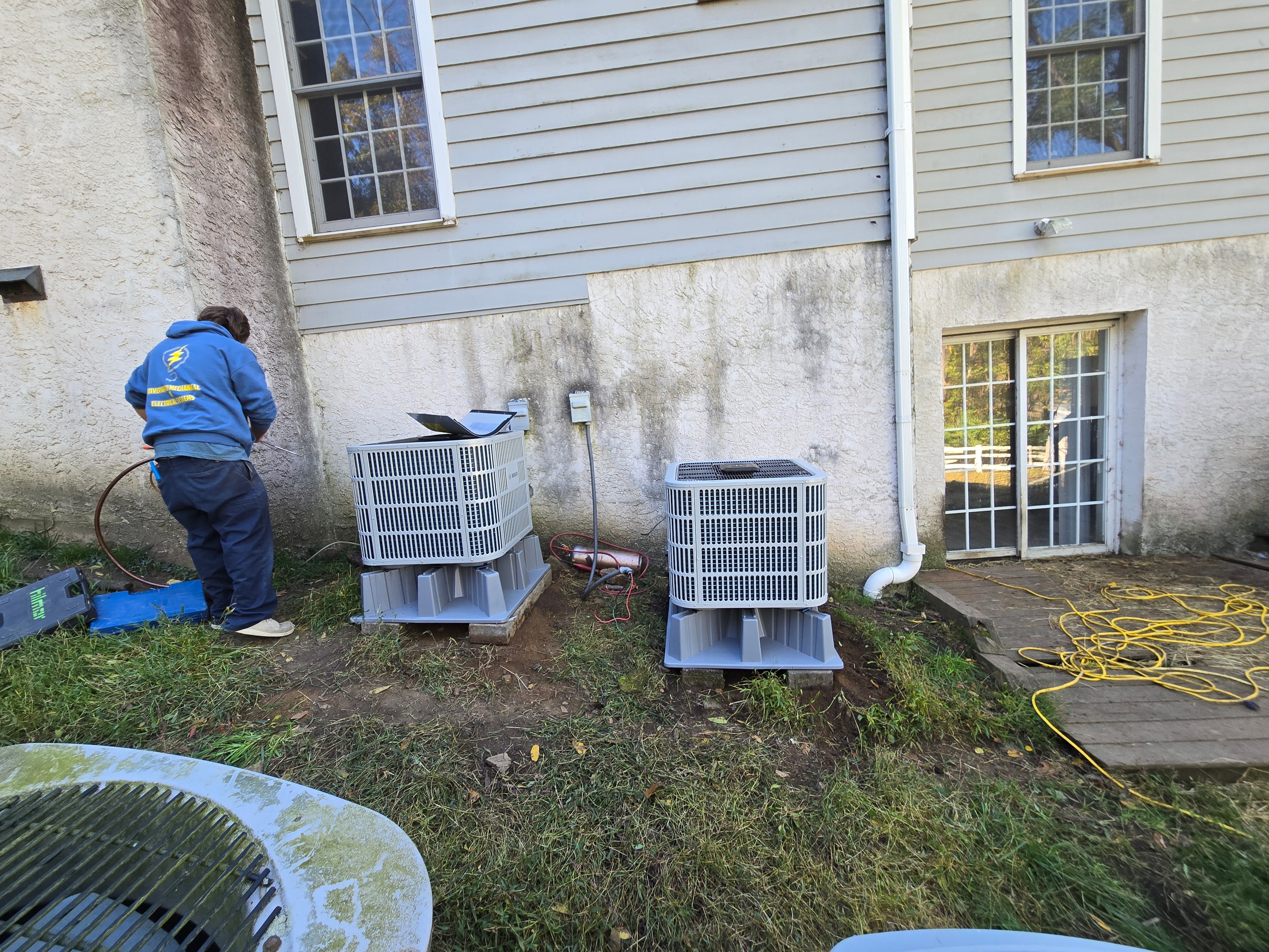 DMES LLC technician servicing residential air conditioning condensing units at a southeastern Pennsylvania home