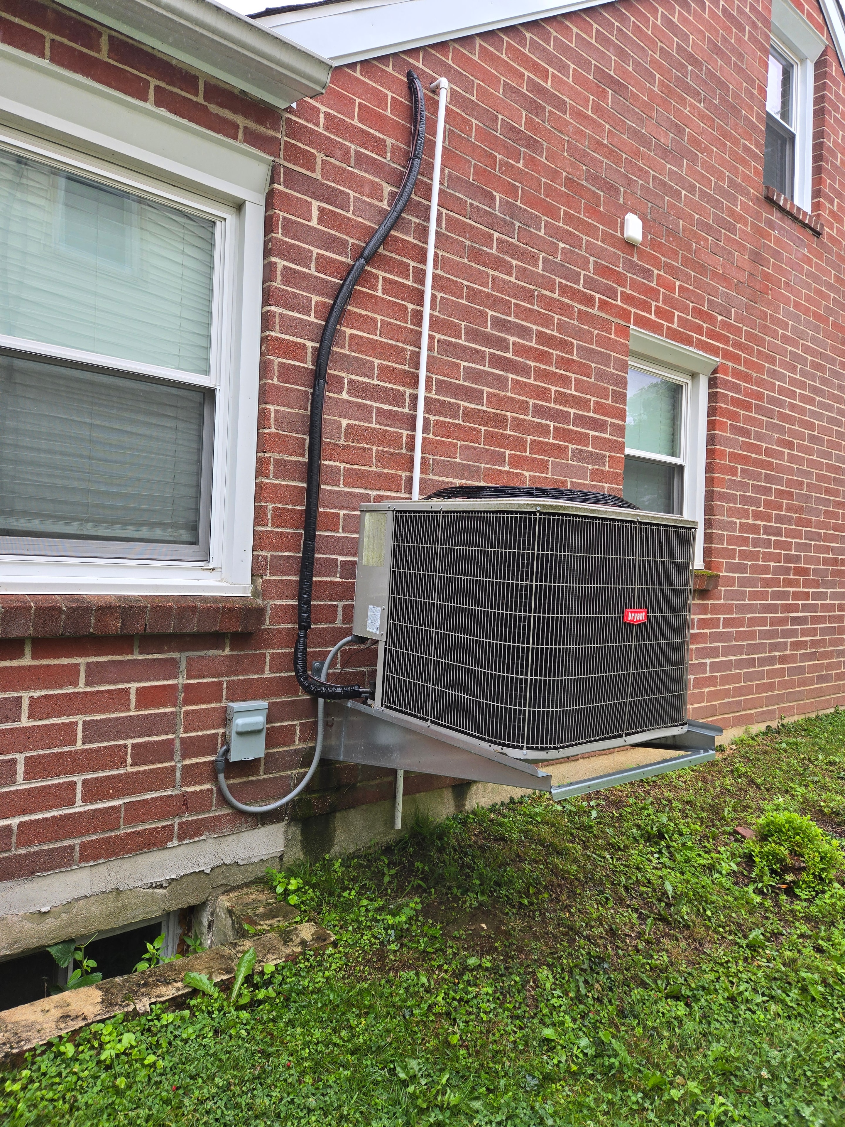 DMES LLC outdoor HVAC condensing equipment mounted on a wall bracket